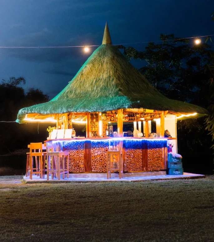 Thatched drinks pavilion glowing with lights at night