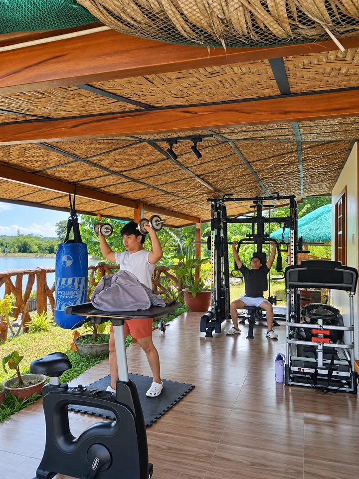 Guests exercising in the open-air gym beside the pond