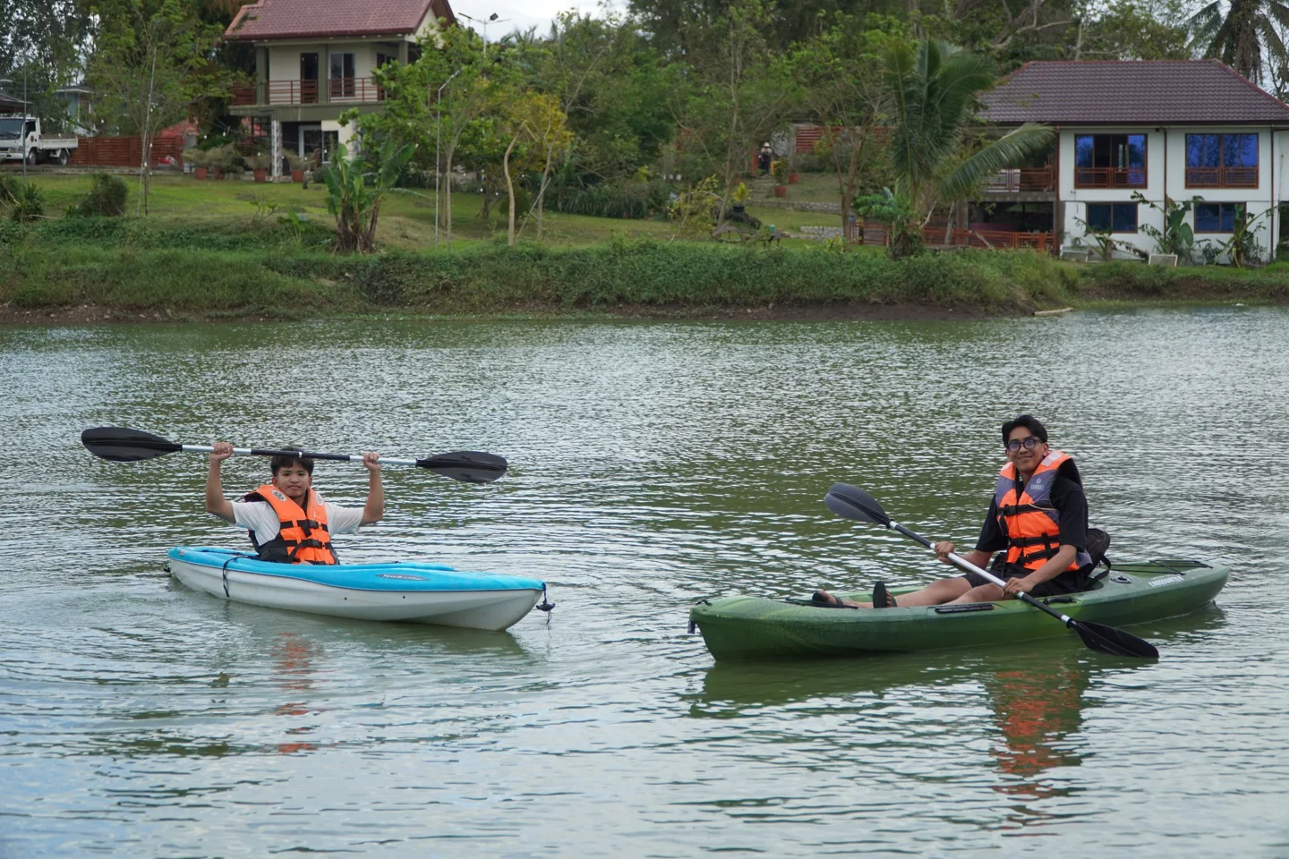 Guests paddling kayaks on the farmhouse water
